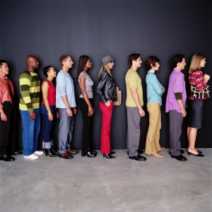 Group of men and women waiting in line, side view